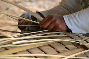 a worker is making a bamboo basket