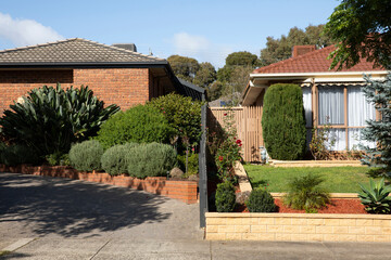 Typical Australian houses sharing fence line in suburban neighbourhood on summers afternoon.