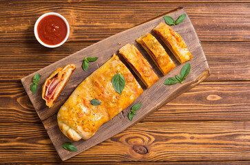Pizza roll stromboli with cheese salami olives and tomatoes