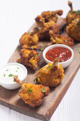 Chicken wings nuggets with sauces on wooden background .