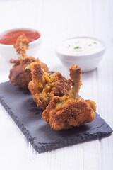 Chicken wings nuggets with sauces on wooden background .