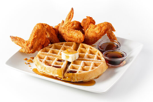Large waffle with crispy fried chicken wings on white background with copy space