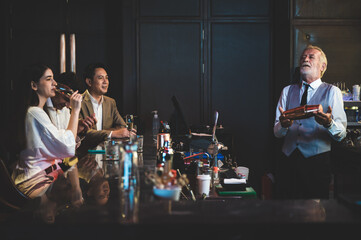 Expert barman is making cocktail at night club, senior bartender working at bar counter