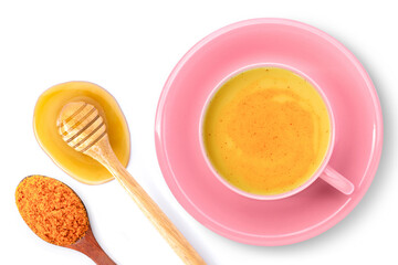 Pink cup of golden milk ( turmeric latte tea ) with tumeric powder and pure honey isolated on white background. Top view. Flat lay.