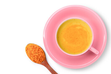 Golden milk ( turmeric latte ) in pink cup with tumeric powder isolated on white background. Top view. Flat lay.