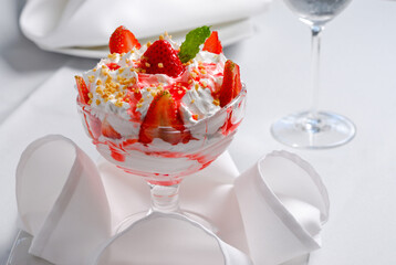 Strawberry dessert with whipped cream and ground nut.