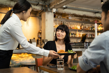 Group of people sitting in indoor restaurant cafe eating food together