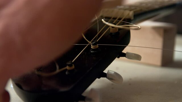 Tying up the extra part of a guitar string into a circle so it's not flying all over the place.  