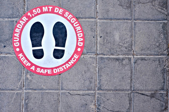 Covid-19 safe distance sign in Spanish and English (Spanish text: guardar 1.5m de seguridad, English translation: keep safe distance of 1.5 meter).