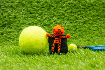 Tennis ball with ghost on green grass for tennis player on Halloween Day