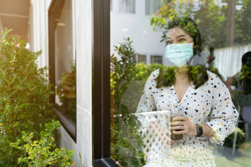 woman wearing face mask for protection coronavirus (covid-19) and drinking chocolate milk in cafe