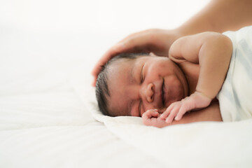 Fototapeta na wymiar african american new born baby lying on white bed