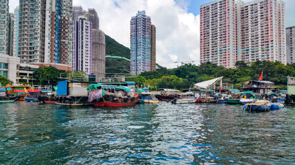 Fototapeta premium City lake with buildings and fishing boats in the background