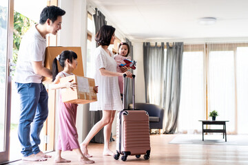 Asian big family moving packing boxes and cloth baggage to new house.