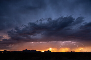 Naklejka na ściany i meble Lightning at sunset during a monsoon storm
