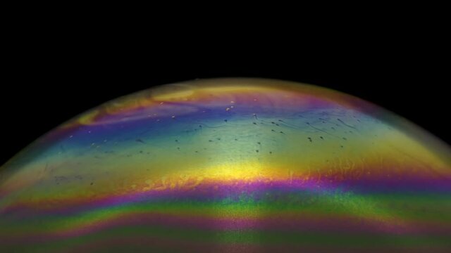 Close-up footage of a soap bubbles surface with colorful and moving texture.