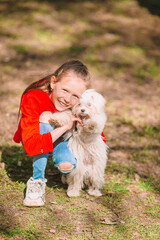 Little girl with a white puppy. A puppy in the hands of a girl