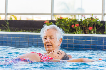 Fototapeta premium Idosa faz relaxamento com criança na piscina