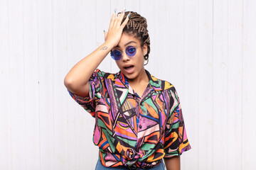 young afro woman raising palm to forehead thinking oops, after making a stupid mistake or...