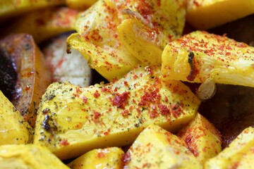 Fried potatoes with vegetables, sprinkled with seasoning close-up.