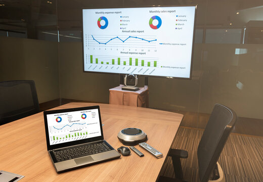 Close Up Laptop On Table With Presentation Meeting On Television In Video Conference Meeting Room (Work From Home Concept)