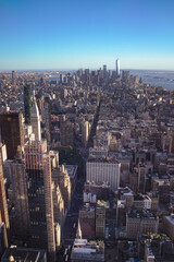 Bird's-eye view of downtown Manhattan under the sunny blue sky in the afternoon.
