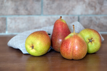 Four Ripe juicy whole pear fruits on a wooden table