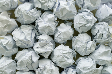 Crumpled paper balls grouped together on a table. Design concept for creativity, mental or writer's block, failed plans, unsuccessful ideas, frustrated but persist in working towards objective.