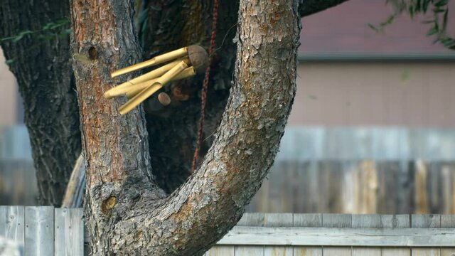 Fierce 70-80 mile per hour winds blow and knock to and fro a wind chime cause it to flail wildly in the strong forced breeze