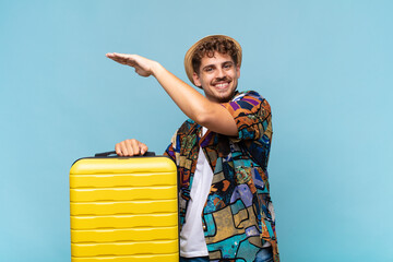 young man smiling, feeling happy, positive and satisfied, holding or showing object or concept on...