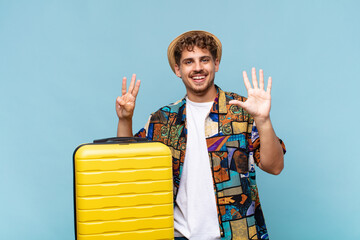 young man smiling and looking friendly, showing number eight or eighth with hand forward, counting...