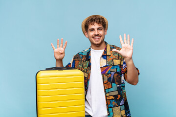 young man smiling and looking friendly, showing number nine or ninth with hand forward, counting...