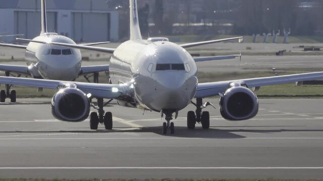 Front view of commercial airplane get on airport runway for takeoff.