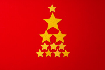 Fototapeta na wymiar Christmas tree made of gold confetti on red background