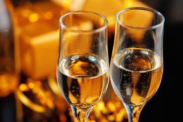 Champagne glass on blurred garland lights background