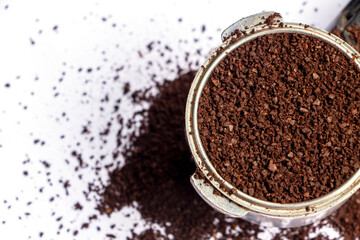 ground coffee in a filter holder on white table