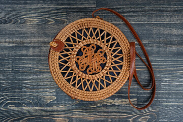 Modern stylish round straw bag on the wooden background