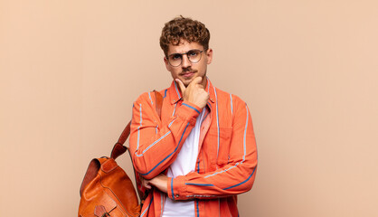 young man looking serious, confused, uncertain and thoughtful, doubting among options or choices....