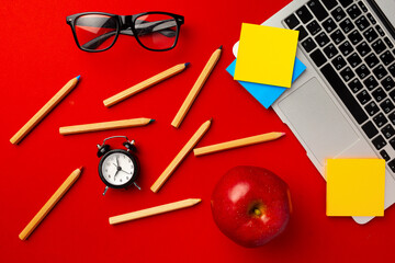 Top view of student working space with open laptop and red apple