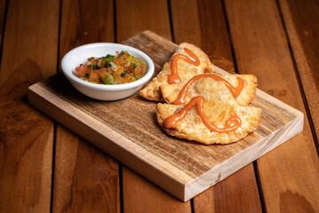 Traditional spanish tapas with tomatoes, greens and avocado sauces on the wood plate board. Tomato sauce. Fried empanadas. Argentine fried meat pies with meet. Fish, seagood. High quality photo.