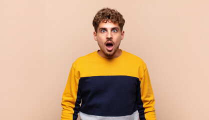 young man looking shocked, angry, annoyed or disappointed, open mouthed and furious