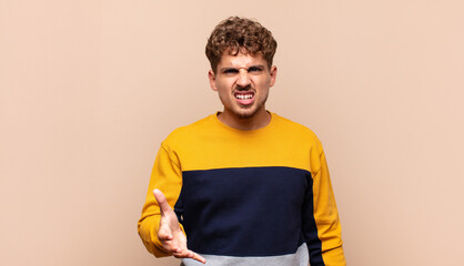 young man looking angry, annoyed and frustrated screaming wtf or what‚Äôs wrong with you