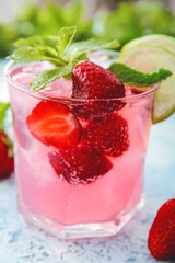 Glass of fresh strawberry mojito on color background