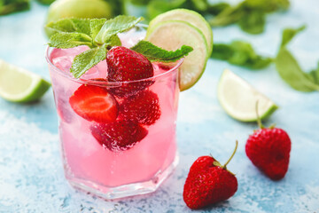 Glass of fresh strawberry mojito on color background