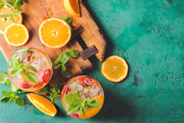 Glasses of fresh strawberry mojito on color background