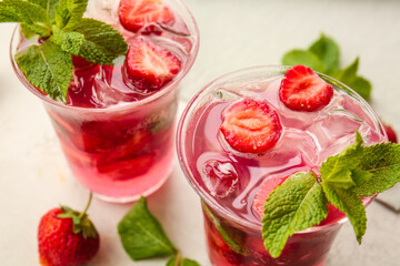 Glasses of fresh strawberry mojito on light background, closeup