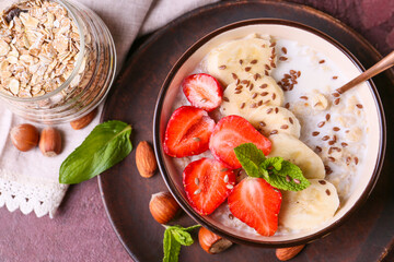 Bowl with tasty sweet oatmeal on table