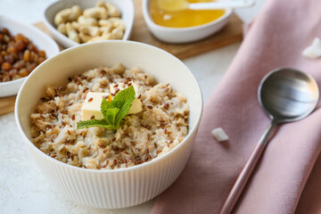 Bowl with tasty sweet oatmeal on table