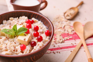 Fototapeta na wymiar Bowl with tasty sweet oatmeal on table