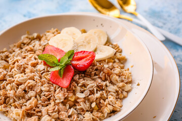 Bowl with tasty sweet oatmeal on table, closeup